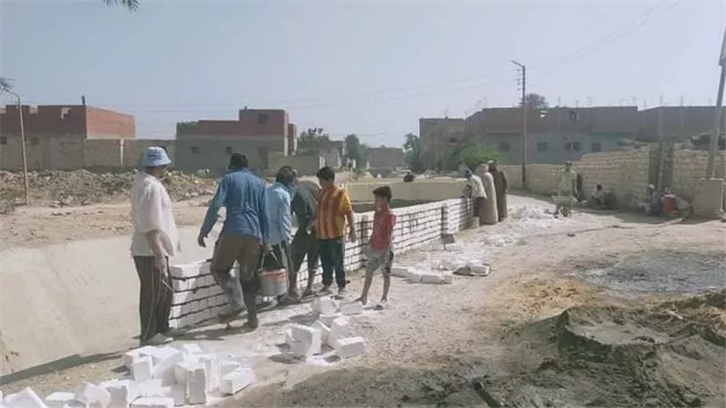 لحماية الأطفال من الغرق..إدارة الأزمة بقرية الودي بالصف تقيم سورا حول ترعة القرية بمسافة ٢.٢ كم بالجهود الذاتية