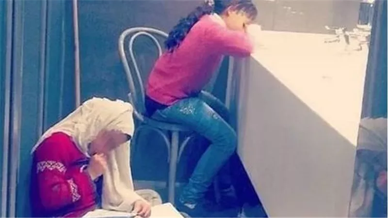أختان تذاكران في حمام عام بسبب عمل الأم.. حكاية صورة أشعلت السوشيال ميديا | شاهد